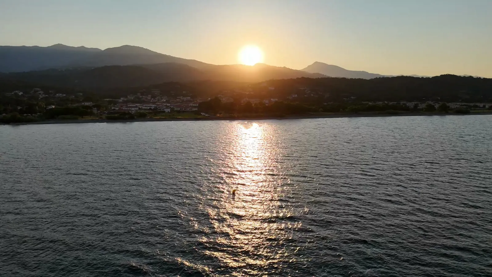 Le soleil se couche derrière la montagne corse, reflet sur l’eau