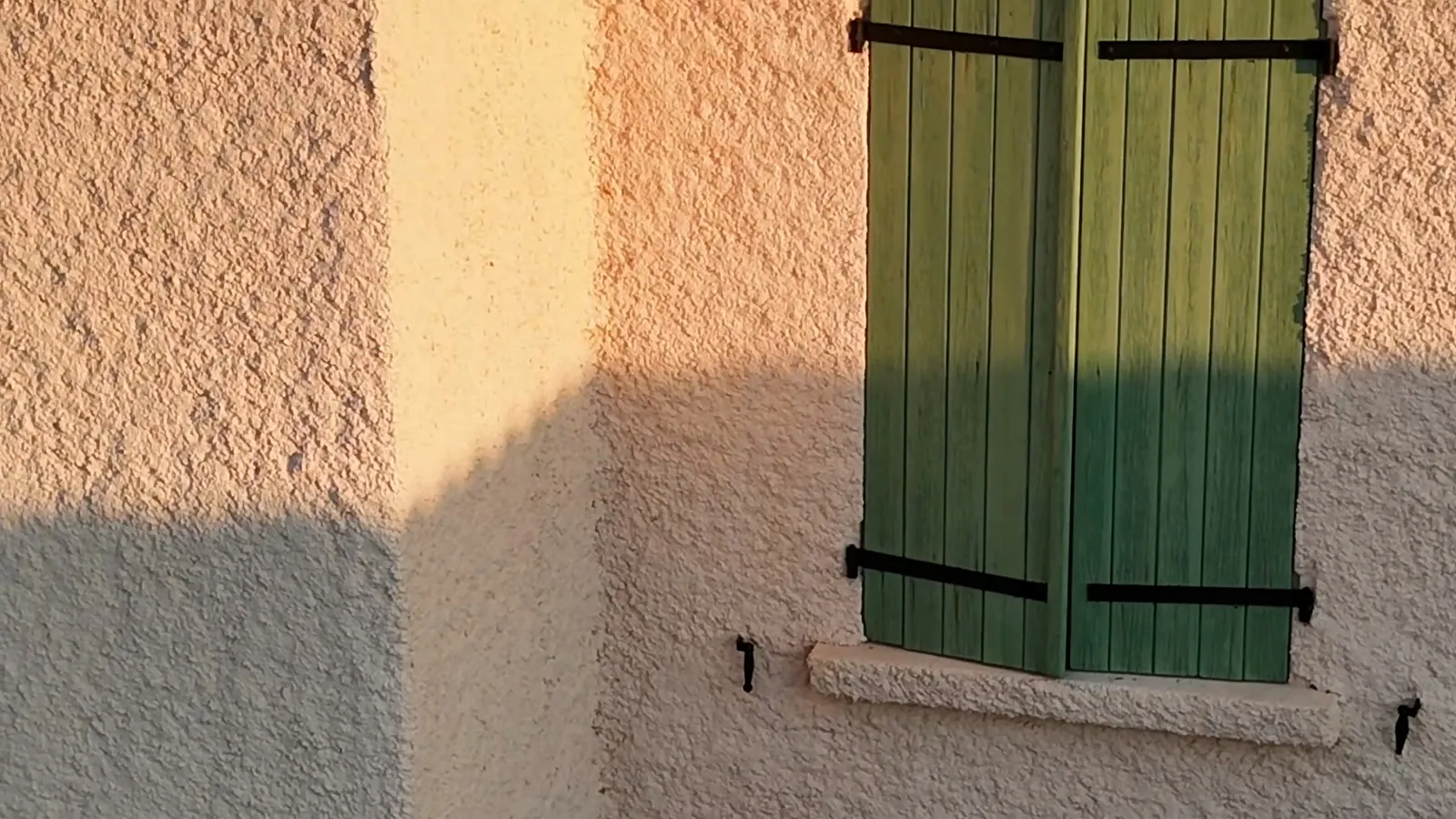 Les volets verts de la maison dans la lumière du soir